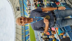 Zdjęcie biegacza z medalem na tle stadionu